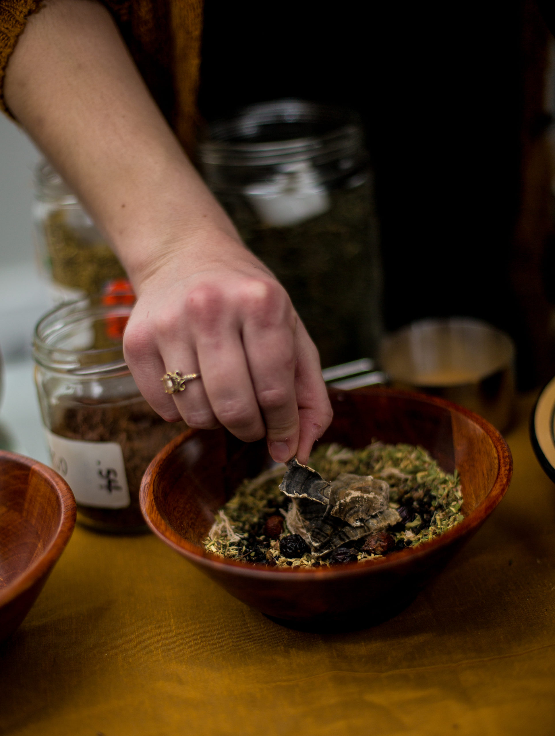 Woman arranges loose leaf tea in a bowl for branding photography session