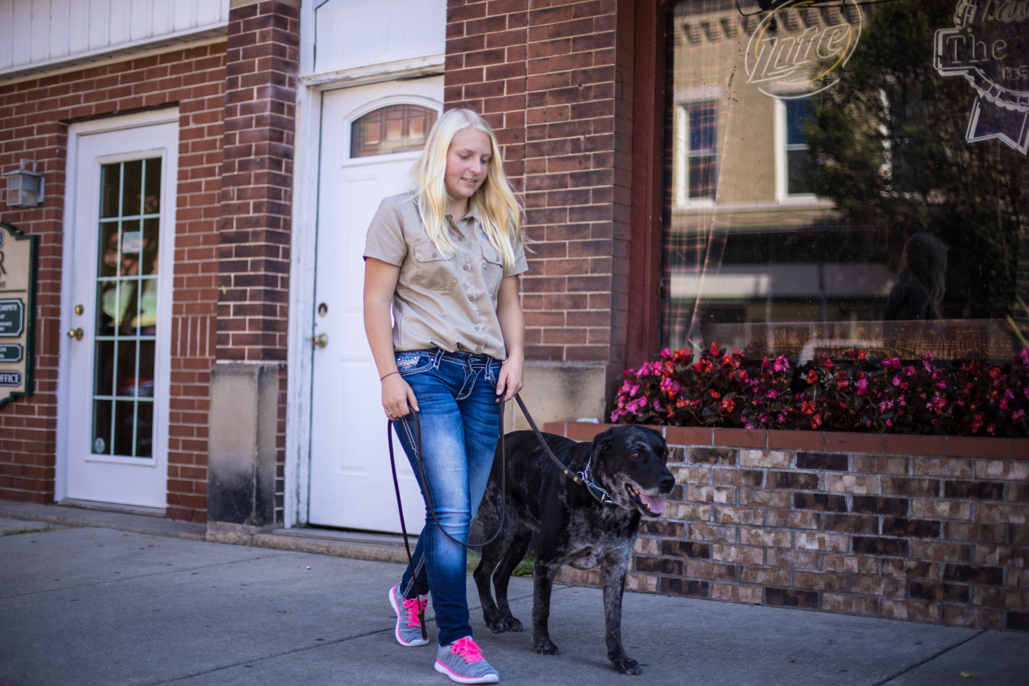 Woman walking a dog outside residential buildings 